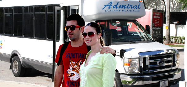 A couple poses infront of the tour buses. 