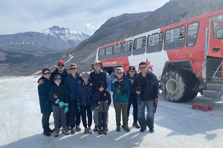 A family takes a group photo on top of the Athabasca Glacier.