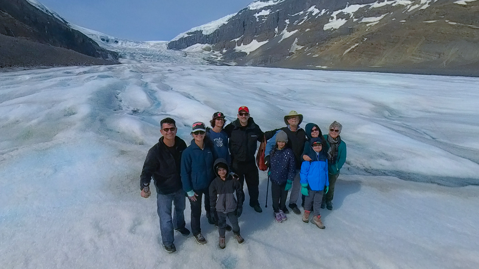A family takes a group photo on the Athabasca Glacier.