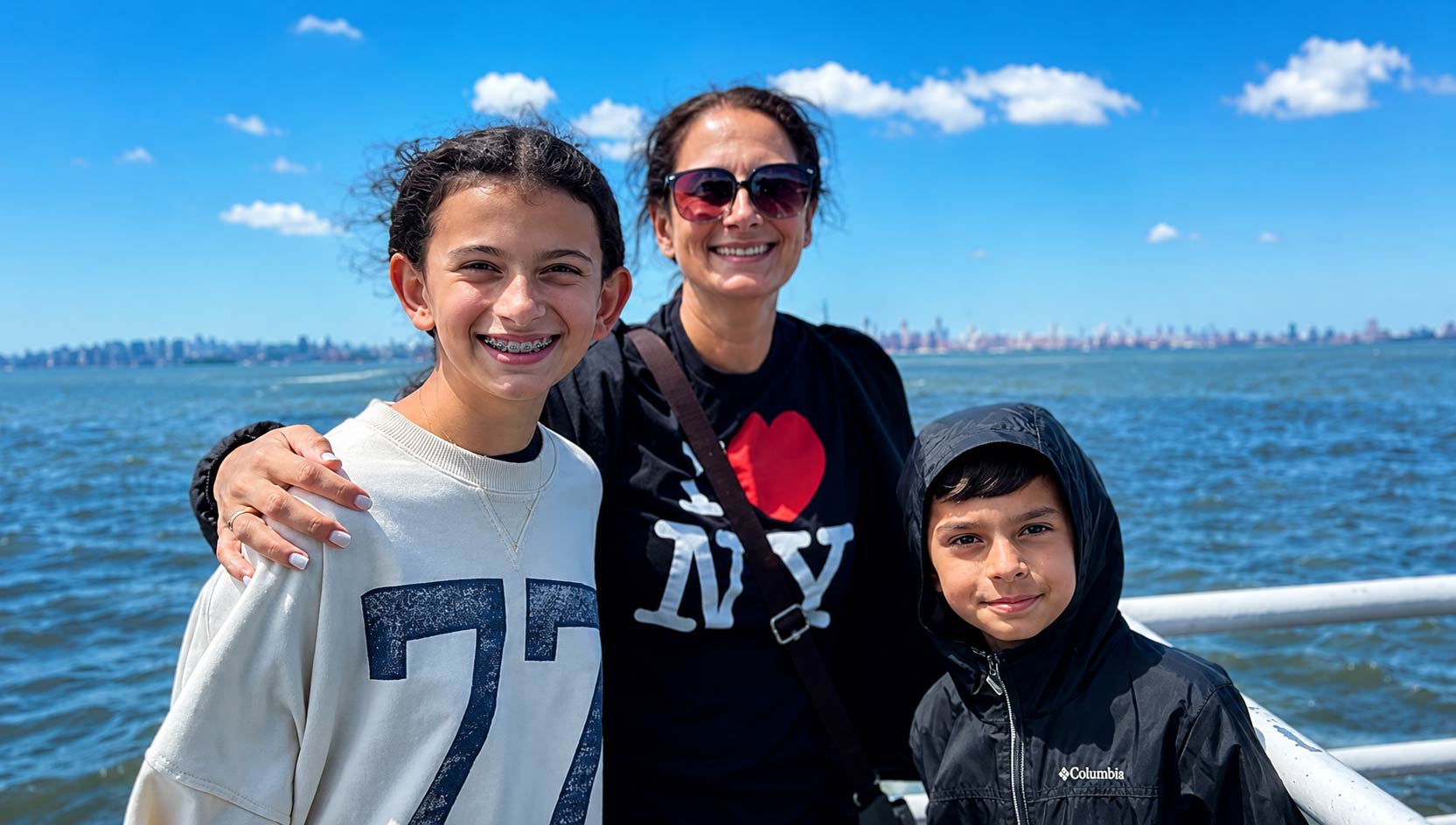 A family of three enjoy their Statue of Liberty cruise. 