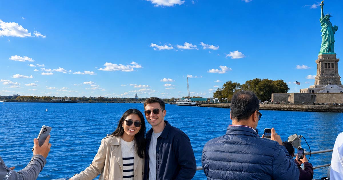 A couple poses in front of the Statue of Liberty during their cruise. 
