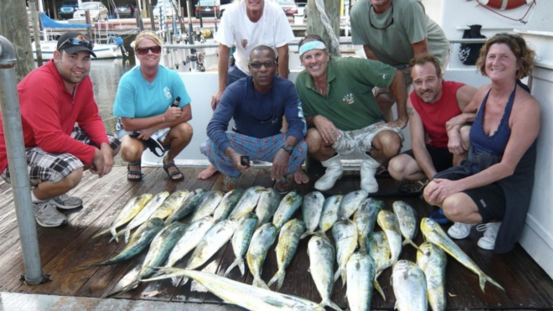 A big group takes a photo in front of their big catch. 