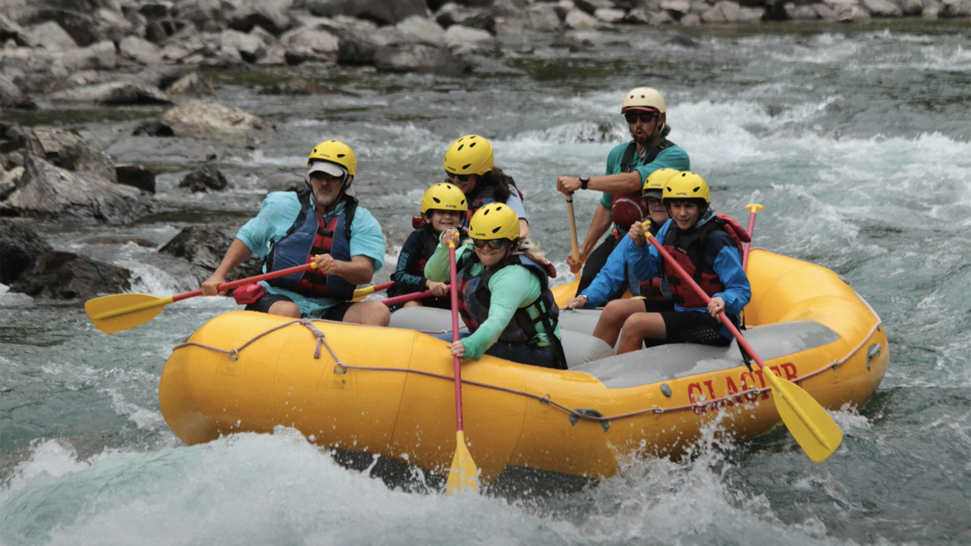A family enjoys rafting in Glacier National Park. 